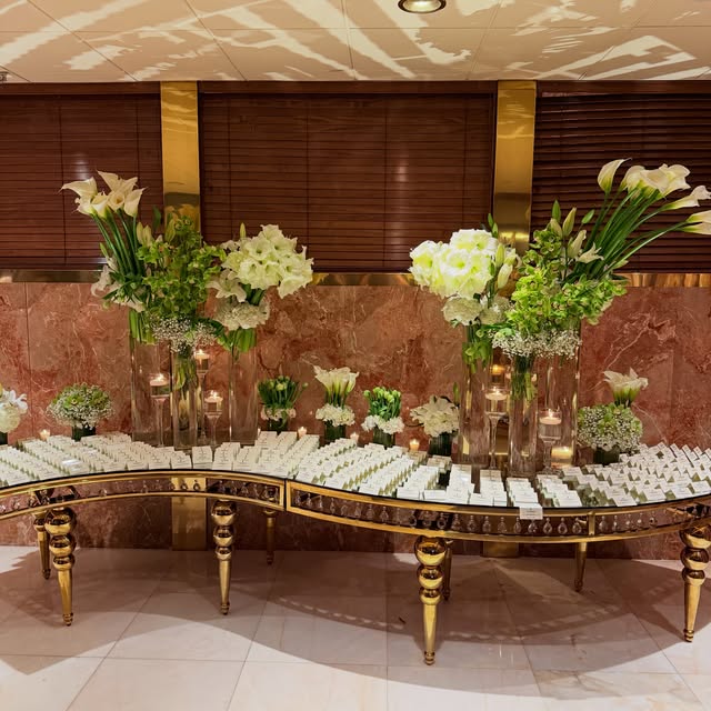Calla lily and white floral arrangements on a gold mirrored table at a corporate gala designed by Royal Floral Designs