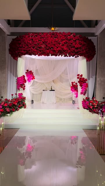Dramatic red floral chuppah over a white stage