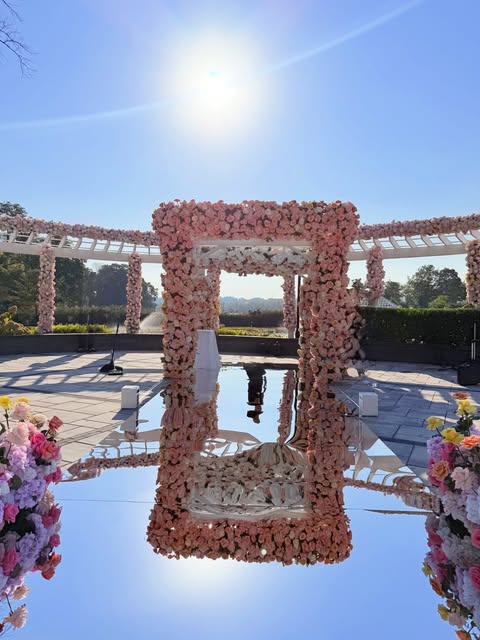 Blush floral photo-frame installation by an estate reflecting pool